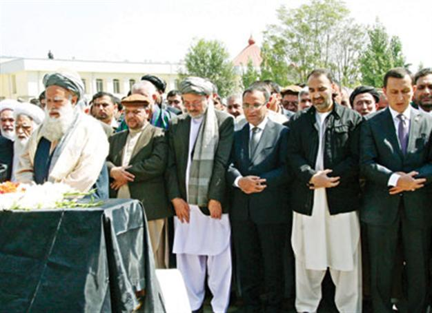 Afghan peace envoy buried to angry scenes
