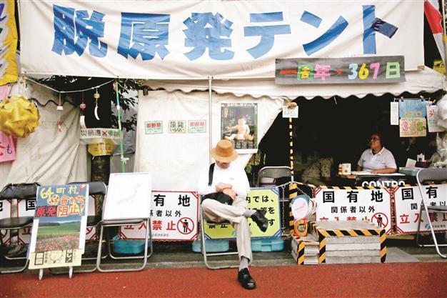 Bank of Japan holds steady policy, warns over economy