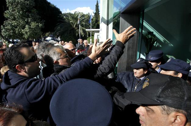 Angry bank clients push way into Greek Cyprus parliament