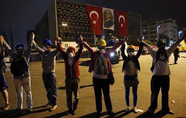 Demonstrators form a human chain to prevent friction with police