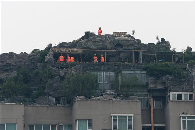 Demolition workers scale Beijing rock villa