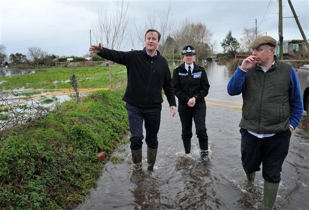 UKs Cameron visits flooded areas as blame game escalates