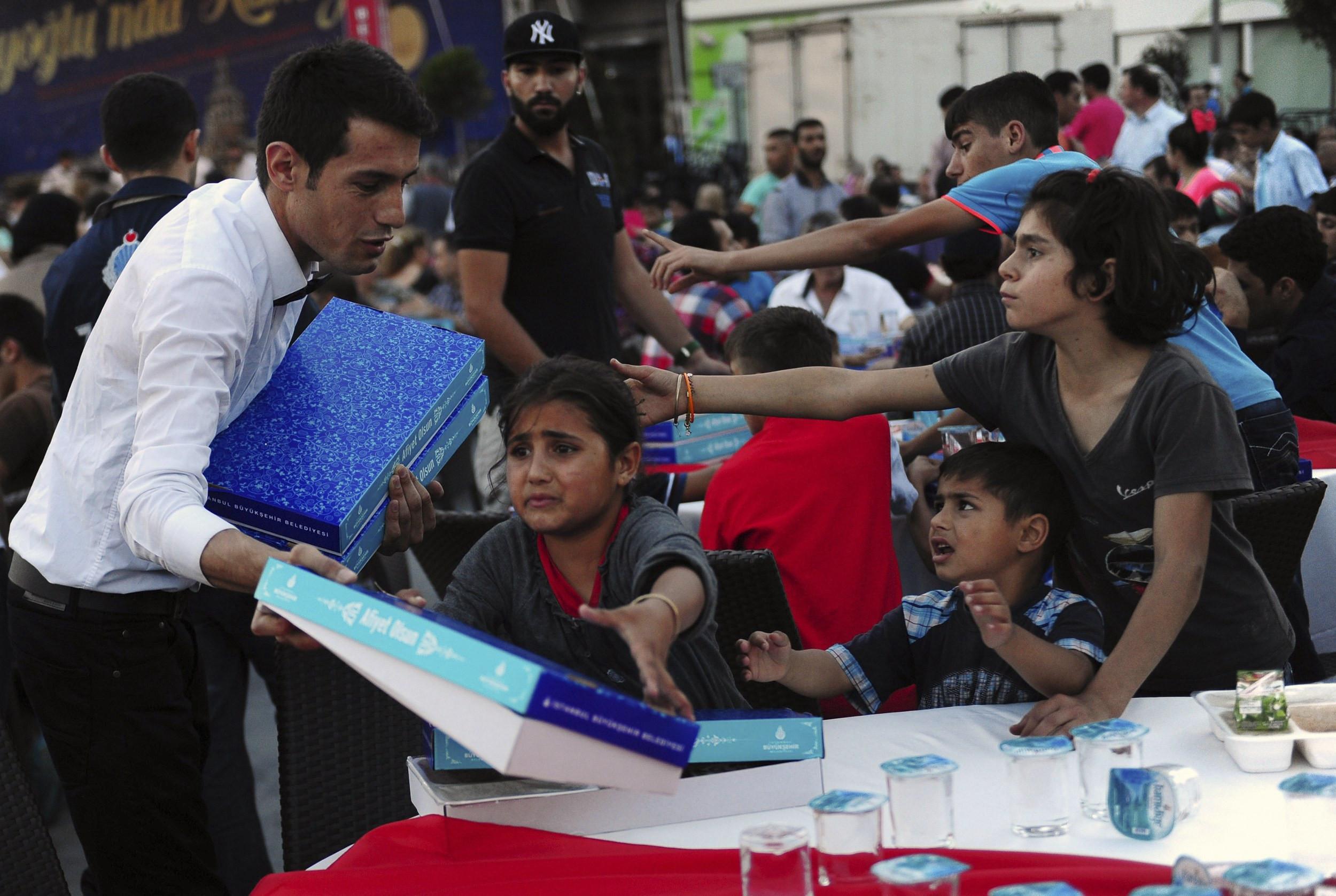 Syrian refugee children strive to get free food during iftar dinners in central Istanbul