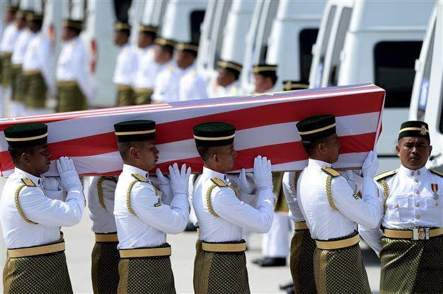 In somber homecoming, Malaysia lays MH17 dead to rest
