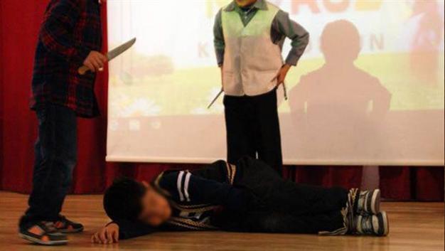 Students performing pretend animal sacrifice in play draw reaction