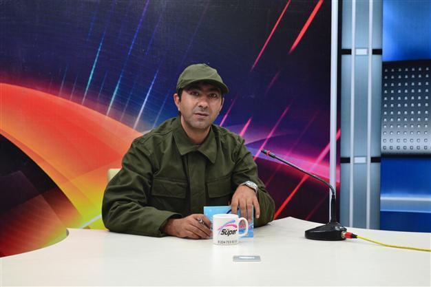Local newscaster reports news in military uniform