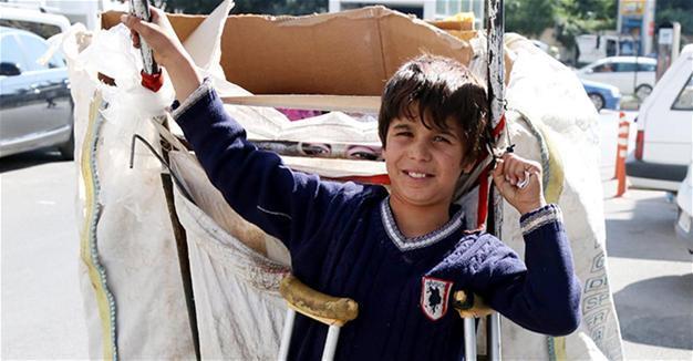 Disabled refugee child gathers paper on street in Turkey’s south for family in Syria
