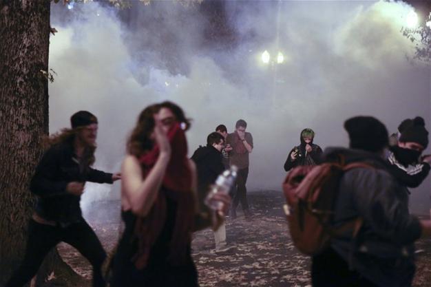 Anti-Trump protesters march amid tear gas, flash grenades