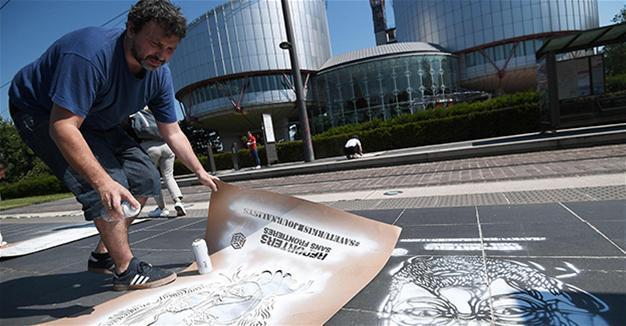 Parisian street artist, RSF paint portraits of jailed Turkish journalists outside Euro court