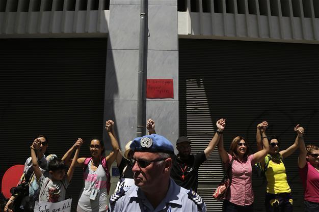 Greek, Turkish Cypriots link arms across border for peace