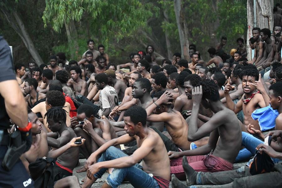 Over 150 migrants storm through Spains enclave fence