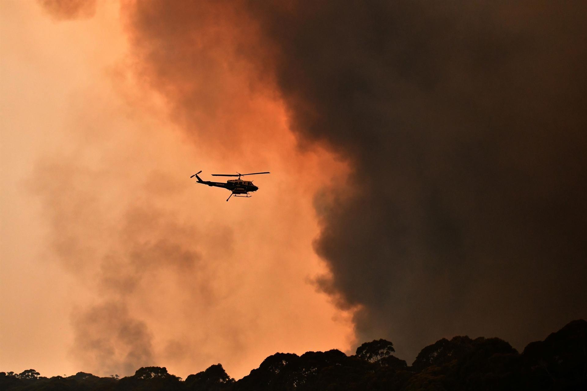 Australian PM apologises for vacation as firefighters killed in huge blazes