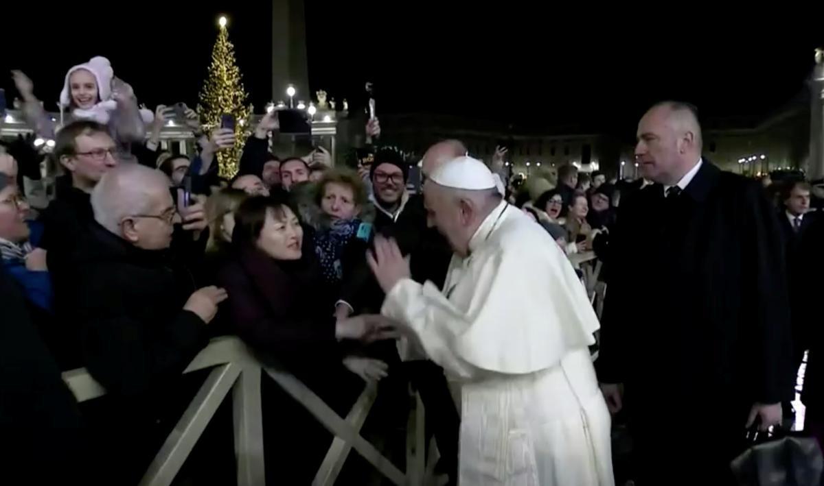 Disgruntled Pope Francis pulls himself free from womans grasp