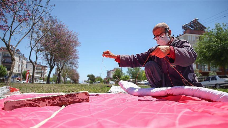 Local man sewing quilts under trees for half century
