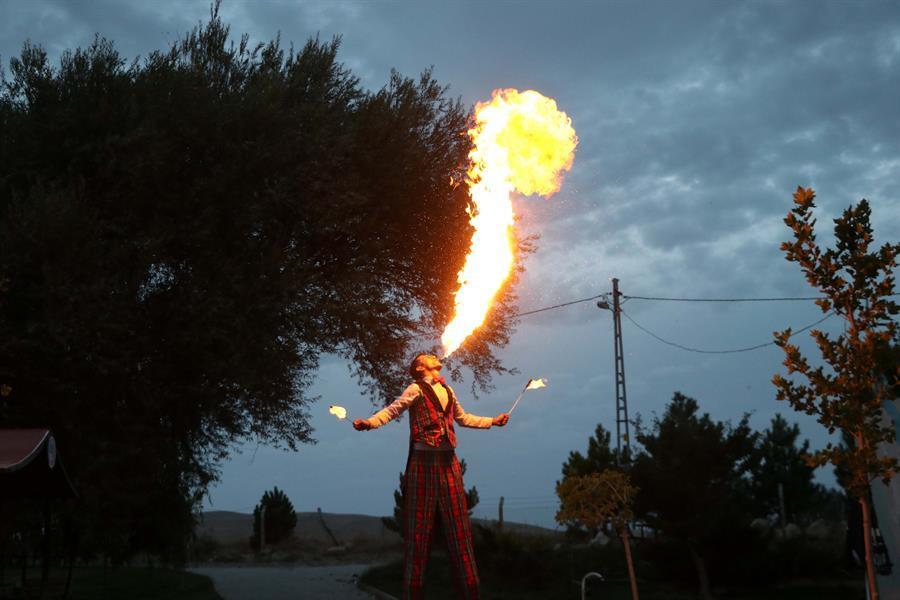 Courier man entertains people wearing 3.4-meter-high wooden stilts