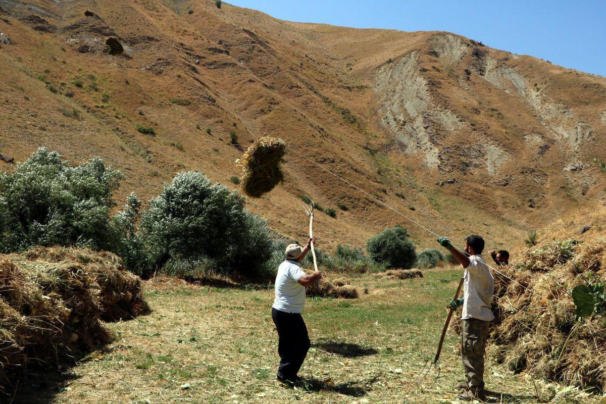 Villagers transport hay bales by zipline