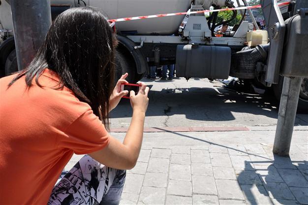 Passersby crowd around to snap photos of accident victim