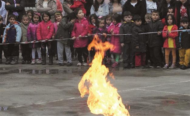 Firemen put burining gas cylinder on fire near kids