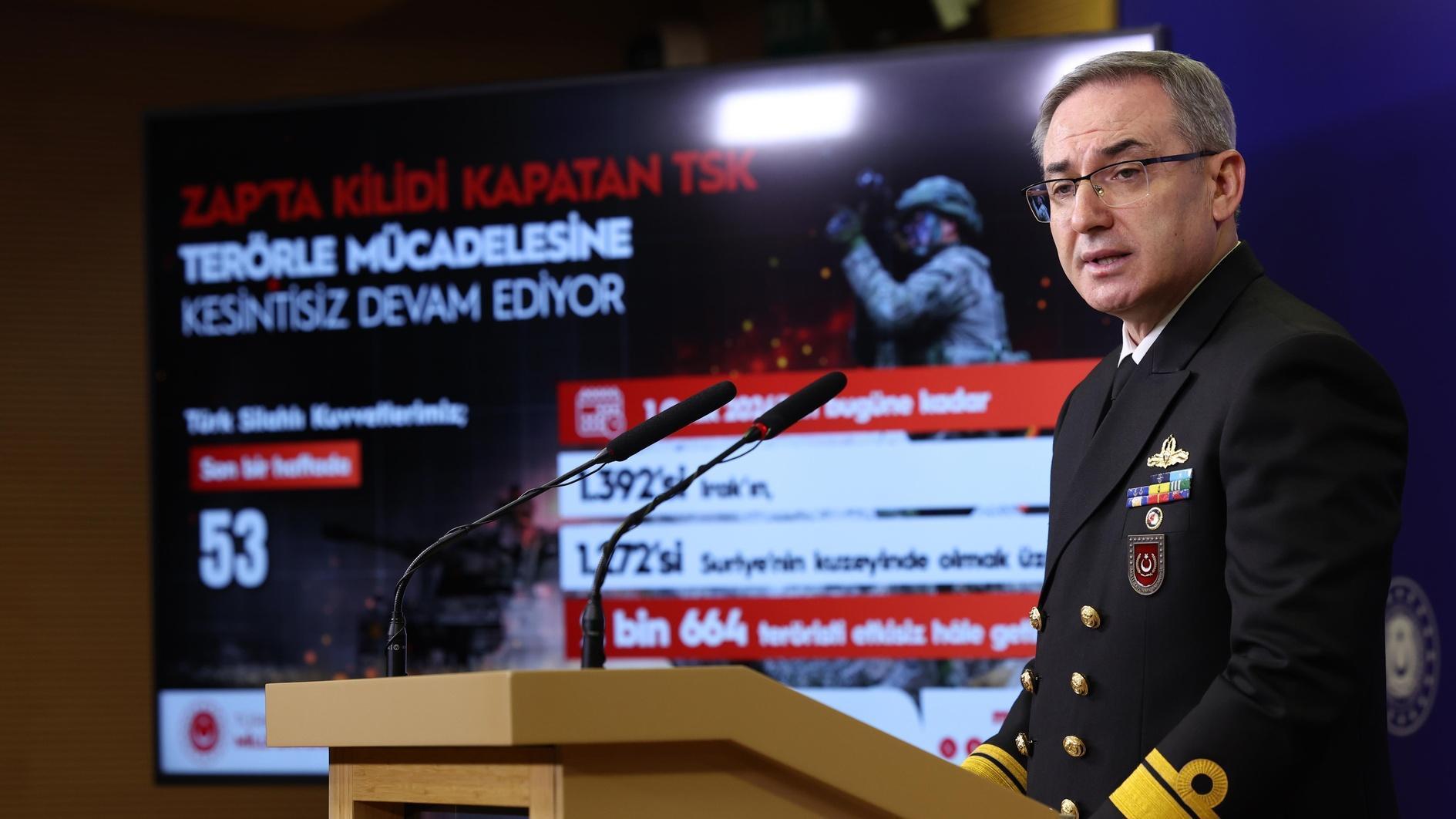 arafed man in military uniform standing at a podium in front of a screen