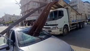 Kamyonun kasasından düşen inşaat demirleri, otomobilin tavanını deldi