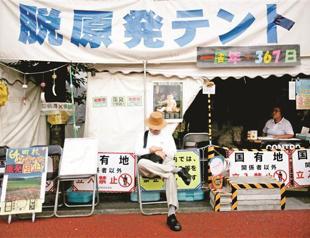 Bank of Japan holds steady policy, warns over economy