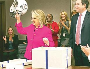 Clinton back to work with applause and helmet gift