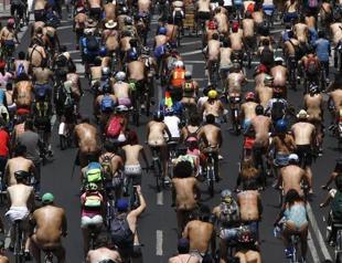 Naked Mexican cyclists riding against drivers