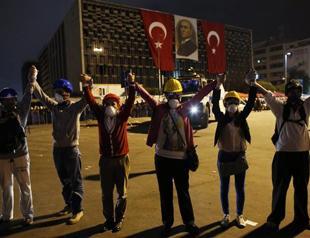 Demonstrators form a human chain to prevent friction with police