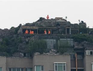 Demolition workers scale Beijing rock villa
