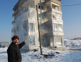 Man covers apartment building with plastic to fight cold in eastern Turkey
