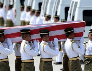 In somber homecoming, Malaysia lays MH17 dead to rest