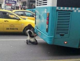 Saddening photo shows Syrian refugee trying to get warm from bus exhaust in Istanbul
