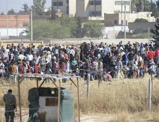 Turkish forces push massing Syrians from border