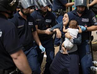 Hungarian police force migrants off train as confrontation emerges