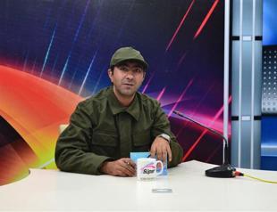 Local newscaster reports news in military uniform