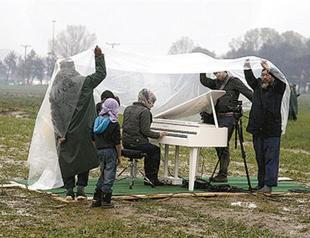 Ai Weiwei brings grand piano to refugee field