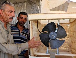 Syrian refugees in sweltering southeast Turkey invent fan-propelled device to cool off