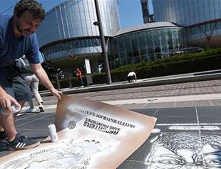 Parisian street artist, RSF paint portraits of jailed Turkish journalists outside Euro court