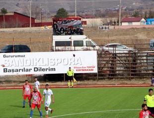 Football fans watch game while barbecuing on van