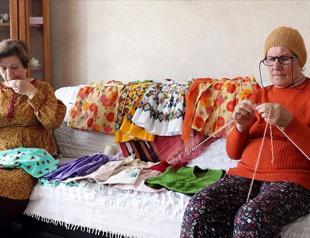 Self-isolating elderly women sew clothes for kids in need