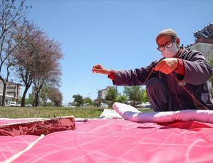 Local man sewing quilts under trees for half century