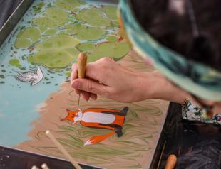 Teacher depicts Turkish fables on water with marble painting art