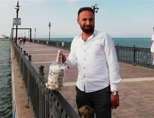 Cafe owner throws wish bottle full of his customers’ messages into Med Sea