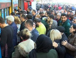 People in scores form long queues to buy lottery tickets