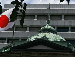 BoJ holds rates, says it will slow bond purchase taper