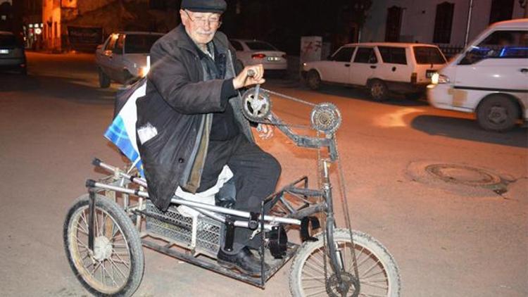 Bisikletin pedalını elleriyle çeviriyor