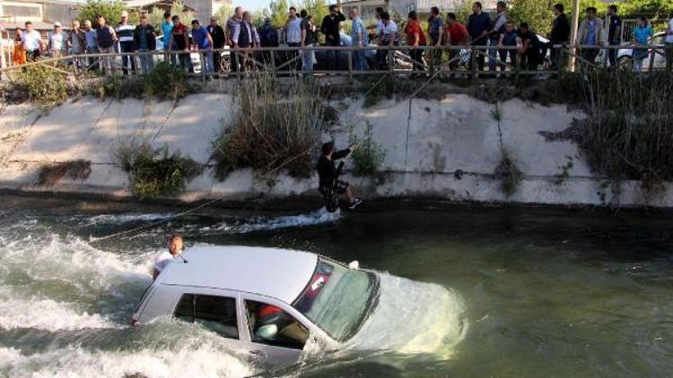 Kanaldaki otomobilde mahsur kalan eşini kurtarmak için hayatını hiçe saydı