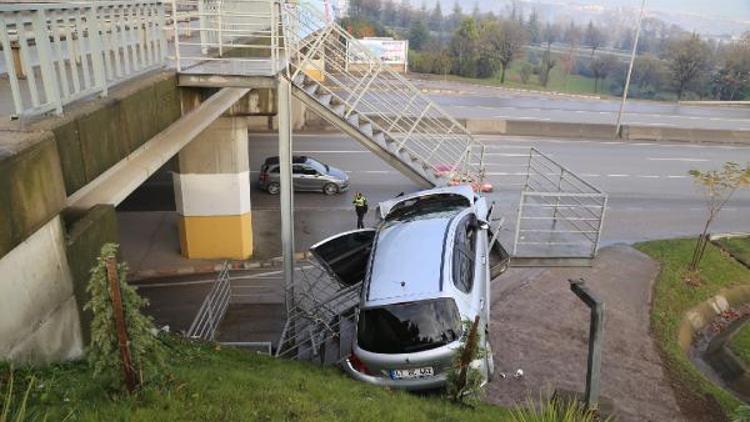 Yoldan çıkan otomobil yaya merdivenlerinde asılı kaldı