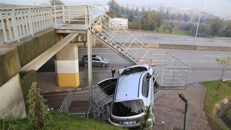 Yoldan çıkan otomobil yaya merdivenlerinde asılı kaldı