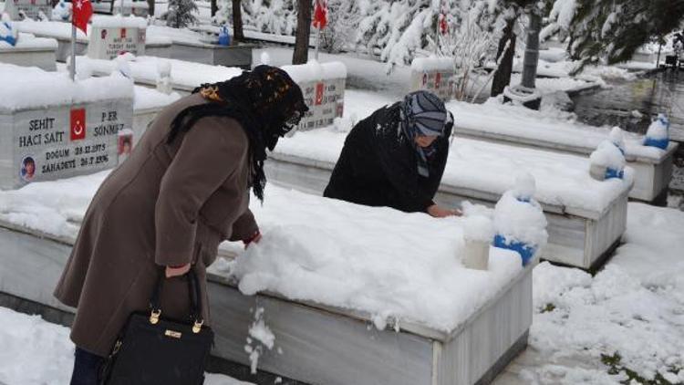 Şehit anaları ve eşleri şehit mezarlarındaki karları temizledi